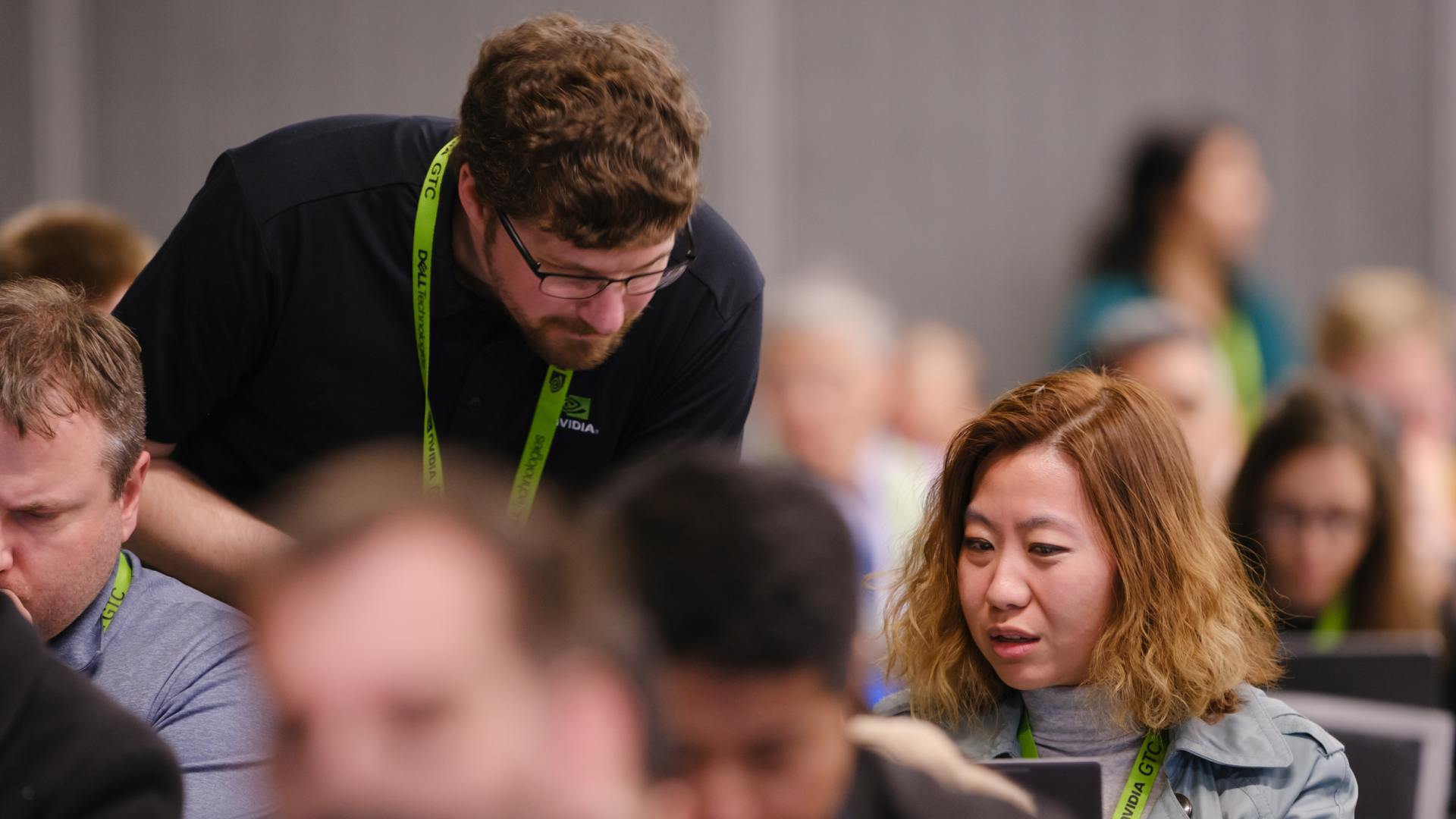 An expert instructor teaches a developer at a GTC workshop